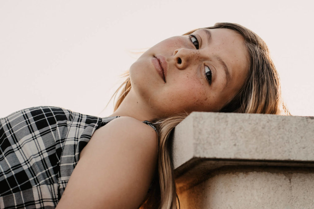 Carlotta sitzt auf der Mauer und schaut auf den Strand El Palmar